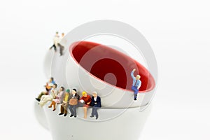 Miniature people : Business team sitting on cup of coffee and having a coffee break. Image use for business concept