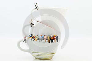 Miniature people : Business team sitting on cup of coffee and having a coffee break. Image use for business concept