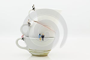 Miniature people : Business team sitting on cup of coffee and having a coffee break. Image use for business concept
