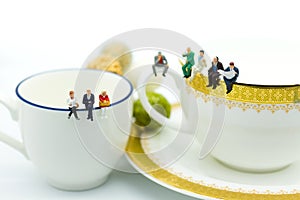 Miniature people : Business team sitting on cup of coffee and having a coffee break. Image use for business concept