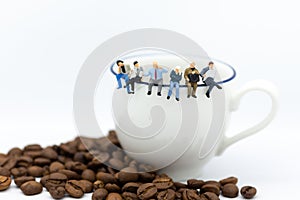 Miniature people : Business team sitting on cup of coffee and having a coffee break. Image use for business concept