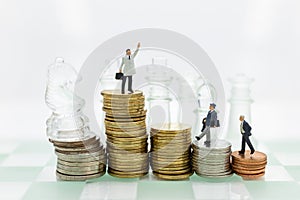 Miniature people : Businessman and chess standing on stack of coin. Image use for financial, business vision concept