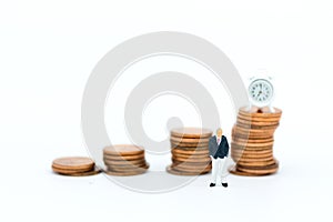 Miniature people: Businessman looking for stack of coins. Image use for background money growth up, saving, financial, business