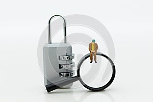 Miniature people: Businessman with a magnifying glass and master key encoding. Image use for background security system