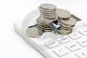 Miniature people: Businessman reading book on calculator and coins, Business and finance investment concept