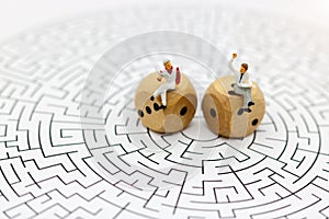 Miniature people: Businessman reading on center of maze. Concept