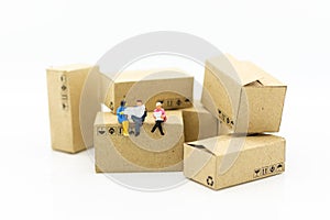 Miniature people : Businessman sitting on box in warehouse. Image use for business, industrial and logistic concept