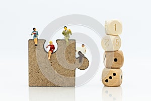 Miniature people : businessman sitting on jigsaw puzzle pieces . Image use for solve, finding solution, business vision concept