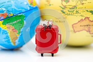 Miniature people : Businessman sitting on red suitcase, world map for background. Image use for travel, business concept