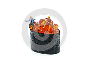 Miniature people : businessman sitting with Salmon egg on sushi