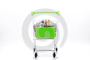 Miniature people : Businessman sitting on shopping cart on stack of coin. Image use for retail business concept