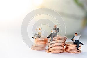 Miniature people:  Businessman sitting on the stack of coins. Image use for business concept