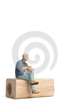 Miniature people Businessman sitting on wooden chair isolated on white background