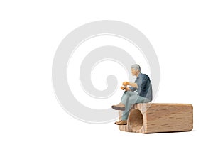 Miniature people Businessman sitting on wooden chair isolated on white background