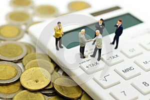 Miniature people: Businessman stand on calculator, calculation tax monthly/yearly. Image use for Tax calculation every year