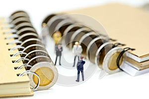 Miniature people : Businessman stand with coins of book,education or business concept.