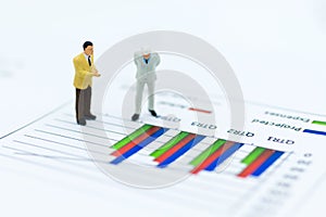 Miniature people: Businessman stand front of dashboard, display graphs, profit margins of background. Image use for business