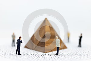 Miniature people: Businessman stand front of graphs on maze map, profit margins of background, risk. Image use for business