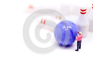Miniature people : businessman stand with Group of Bowling Pins,business and sport concept.