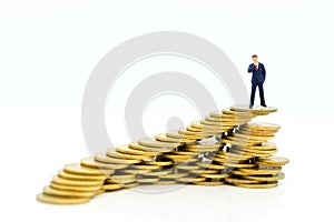 Miniature people : Businessman standing on a coin stacked increase up respectively, used as a business concept photo