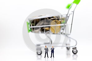 Miniature people : Businessman standing with shopping cart on stack of coin. Image use for retail business concept