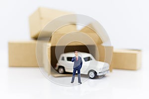 Miniature people: Businessman standing with white car. Work and save money to buy a car. Image use for saving money