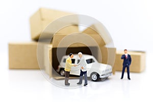 Miniature people: Businessman standing with white car. Work and save money to buy a car. Image use for saving money