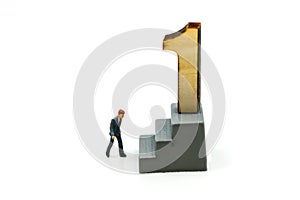 Miniature people : Businessman standing with wooden number of 1,to be the first,Business competition Concept.