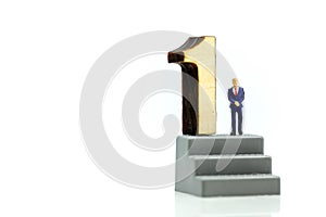 Miniature people : Businessman standing with wooden number of 1,to be the first,Business competition Concept.