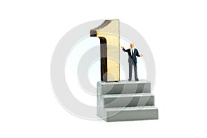 Miniature people : Businessman standing with wooden number of 1,to be the first,Business competition Concept.