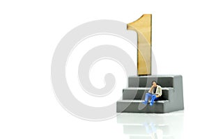 Miniature people : Businessman standing with wooden number of 1,to be the first,Business competition Concept.