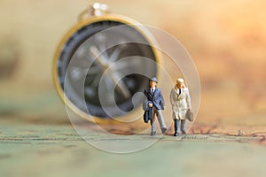 Miniature people : businessman standing on a world map, have compass for background, using as business concept