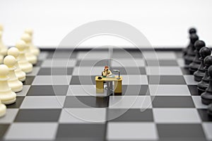 Miniature people businessmen on a chessboard with a chess piece on the back Negotiating in business. as background business