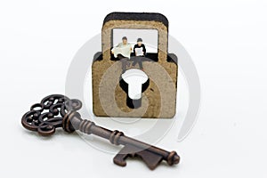 Miniature people: Businessmen sitting on the master key and reading newspaper. Image use for key man, the key to success, business