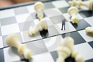 Miniature people businessmen standing on a chessboard with a chess piece on the back Negotiating in business. as background