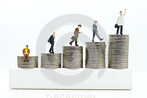 Miniature people : Businessmen standing on a coin stacked increase up respectively, used as a business concept photo