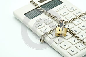 Miniature people businessmen standing Investment Analysis Or investment Key lock and chain at white calculator, lock concept, fin