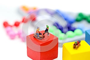 Miniature people : Child having fun to play slider on Colorful