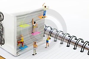 Miniature people: Climber climbing on book . Image use for learning, education concept