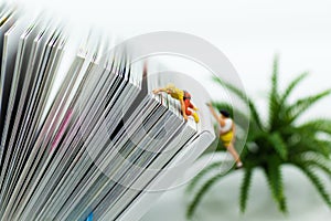 Miniature people: Climber climbing on book . Image use for learning, education concept.