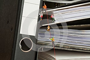 Miniature people climbing binders photo