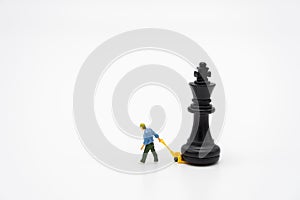 Miniature people Construction worker with a chess piece on the back. as background business concept with copy space