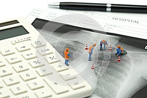 Miniature people Construction worker on white calculator with Lung x-ray .using as background Healthcare concept and Medical conce