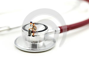 Miniature people : Couple of oldman sitting with medical stethoscope,heathcare concept.