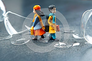 miniature people. a couple of people near a broken hourglass. crisis of personal relationships. concept of communication and