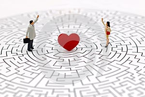 Miniature people: Couple standing on center of maze with red heart.