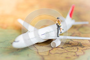 Miniature people : Couples traveling by airplane, plane on a world map, used as a business travel concept