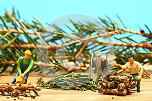 Miniature people cutting up a christmas tree