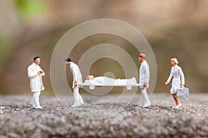 Miniature people : Doctor with nurse carry the patient on a stretcher