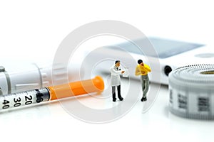 Miniature people : Doctor and patient with Glucose meter diabetes test and Syringe with measuring tape,concept of diabetes, heal